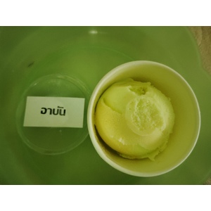 ภาพนี้แสดงถ้วยไอศกรีมสีอ่อน (โทนเหลือง-เขียว) วางอยู่บนถาดสีเขียวอ่อน
ถ้วยไอศกรีมนี้มีเนื้อไอศกรีมสองสีผสมกันอย่างนุ่มนวล คาดว่าอาจเป็นรสผลไม้ เช่น มะนาว หรือเสาวรสผสมมะม่วง หรือรสชาติในกลุ่มผลไม้เมืองร้อนที่ให้ความสดชื่น
ด้านซ้ายของถ้วยมีป้ายที่เขียนว่า
"อาบัน"
